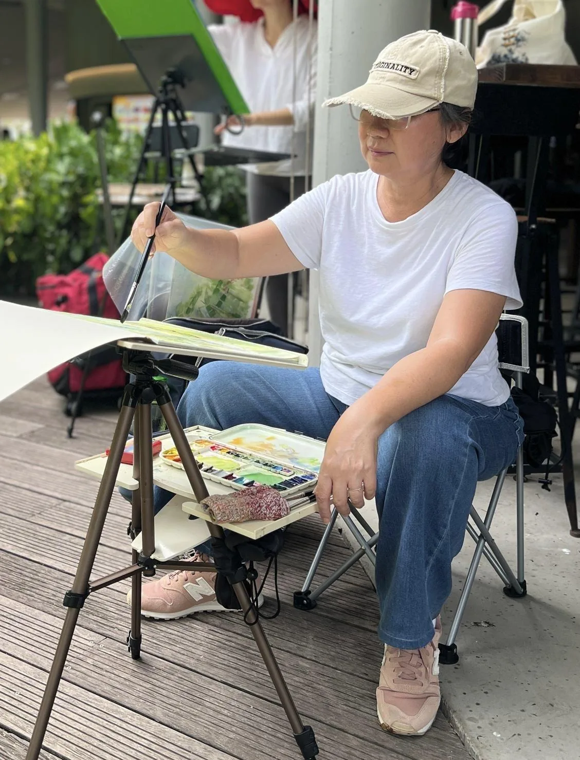 One of the four Singapore watercolour artists holds up her work
