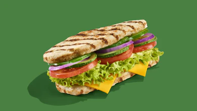 The Wondersub with two chicken breast patties, cheese, lettuce, tomato, cucumber, red onion and sauce against a green background