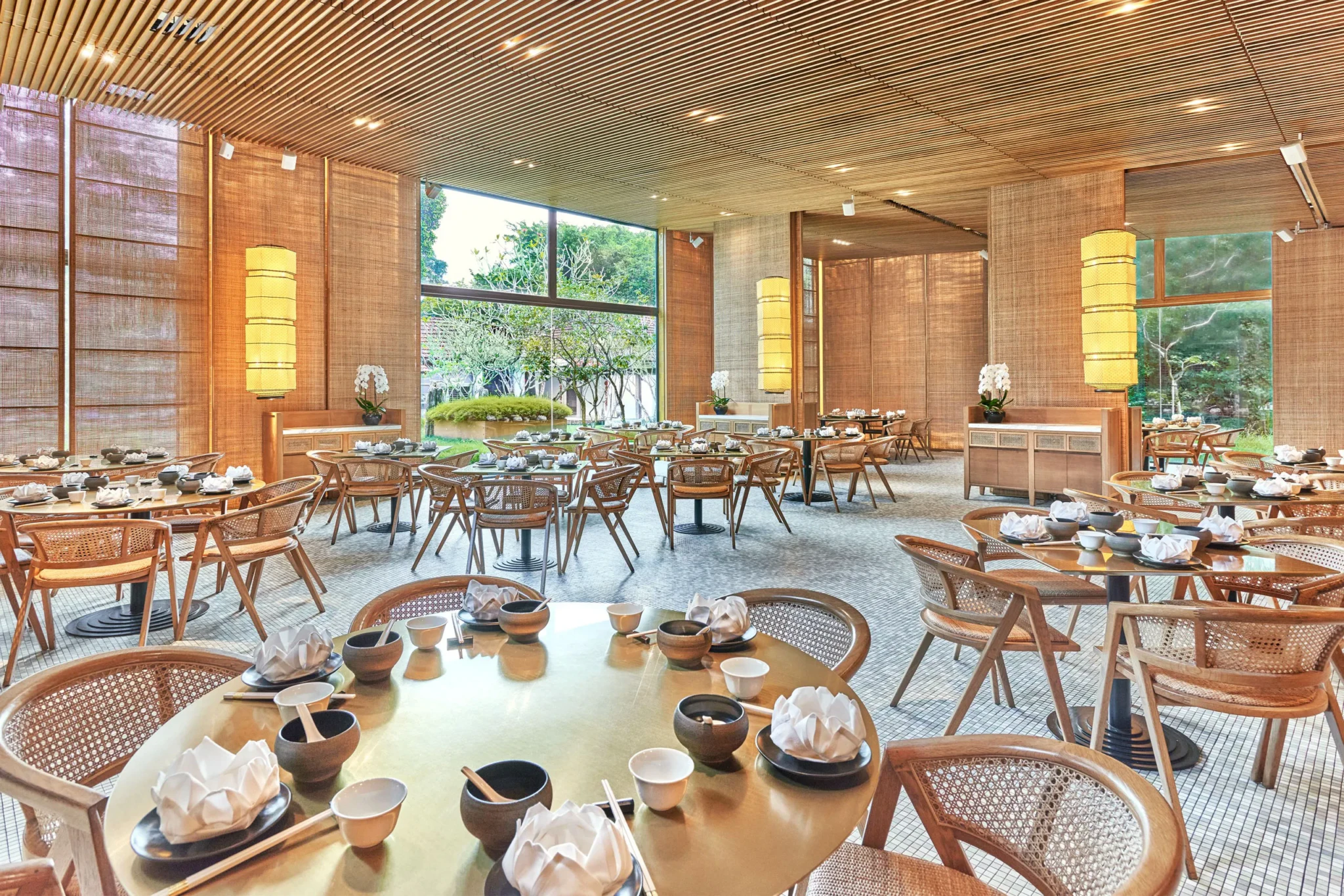 Modern Asian restaurant interior with wooden chairs, round tables, and large windows
