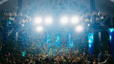 A party crowd under stage lights and falling confetti at an earlier Amber Lounge night.
