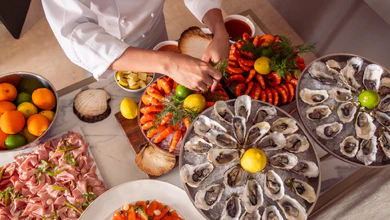 A chef arranges a seafood spread at Mondrian Singapore Duxton's Bottega di Carna.