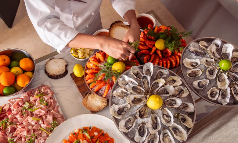 A chef arranges a seafood spread at Mondrian Singapore Duxton's Bottega di Carna.