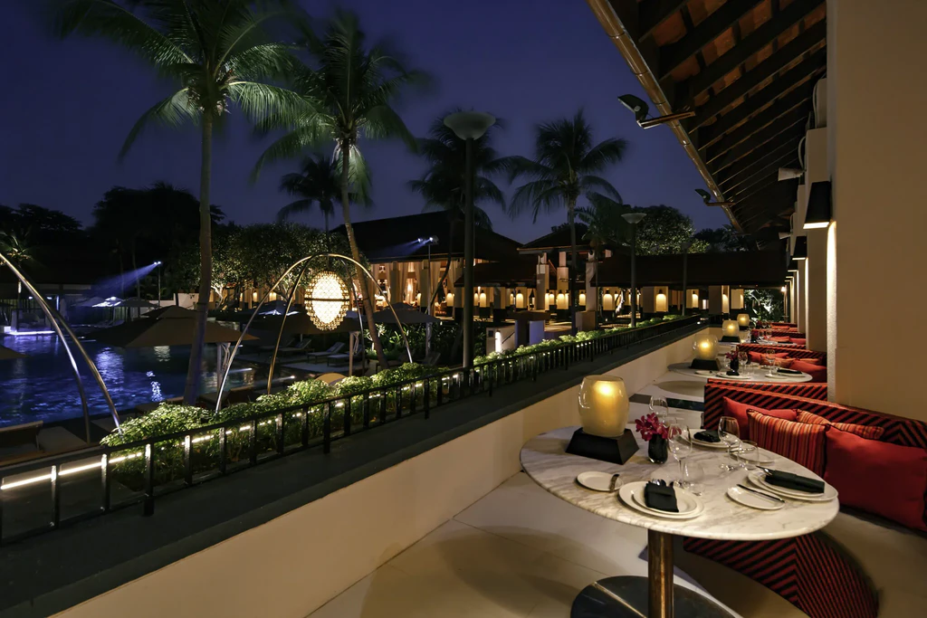 Kwee Zeen's outdoor dining terrace at Sofitel Singapore Sentosa at night.