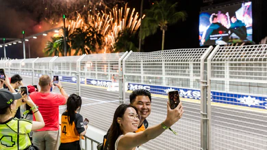 Fans at the Zone 1 Skyline Grandstand with fireworks above the circuit.