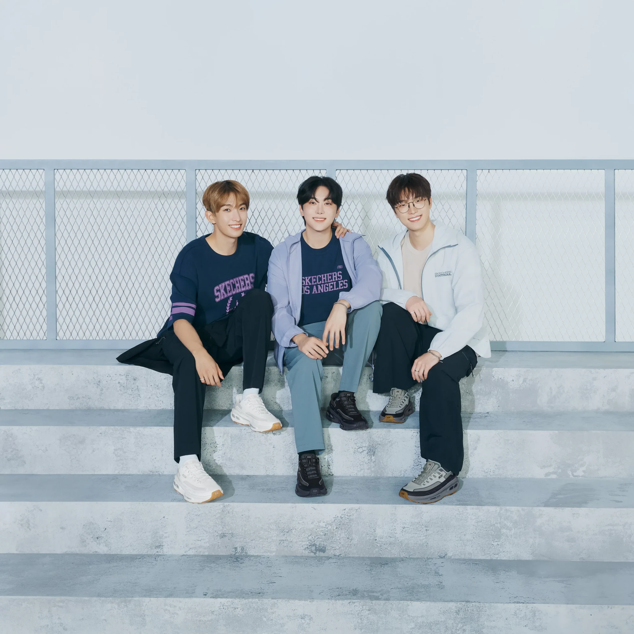 Members of SEVENTEEN sit on concrete steps wearing Skechers apparel and D'Lites 330 sneakers