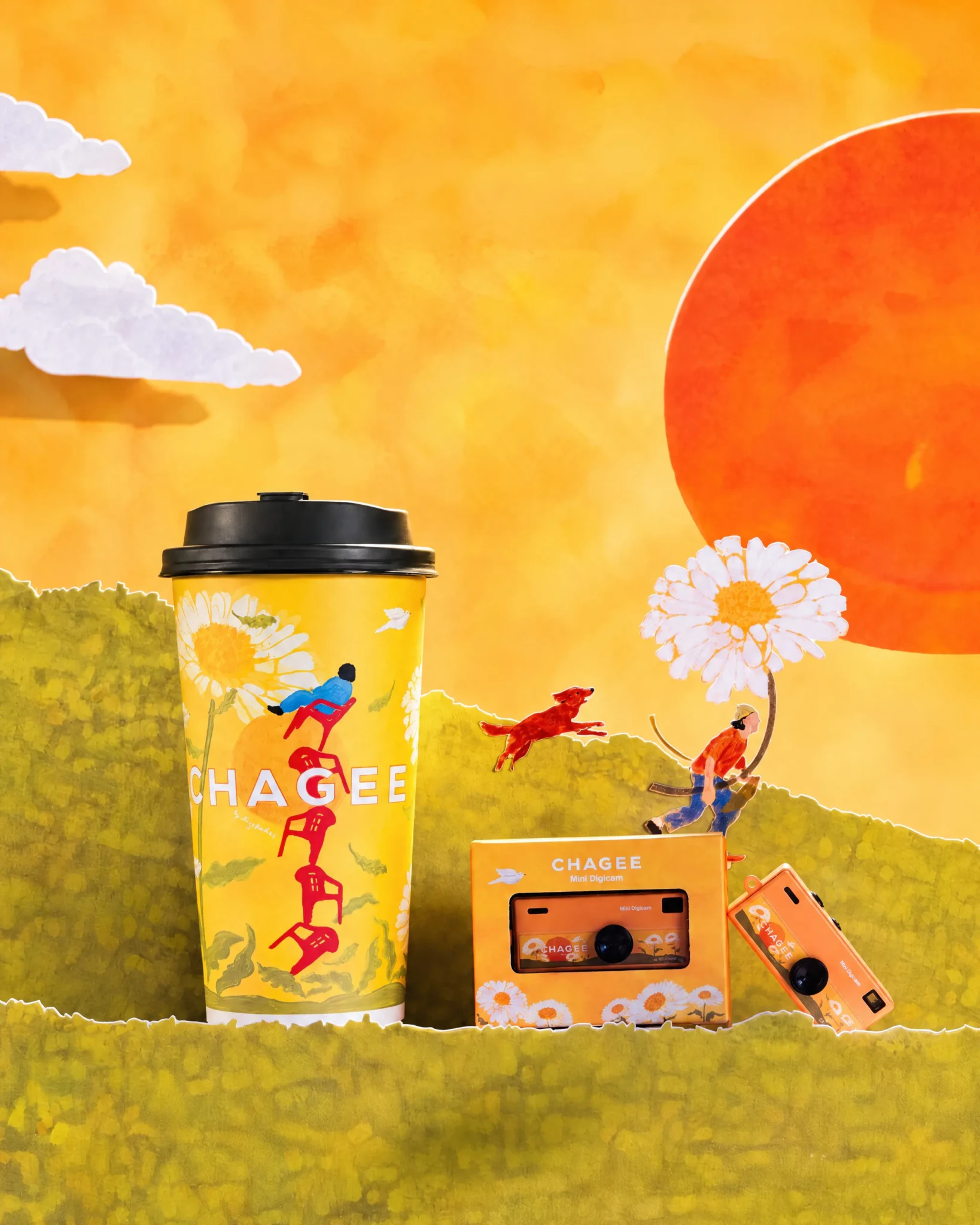The CHAGEE Mini Digicam and a CHAGEE cup in a paper-craft scene with daisies, a red dog and a small figure