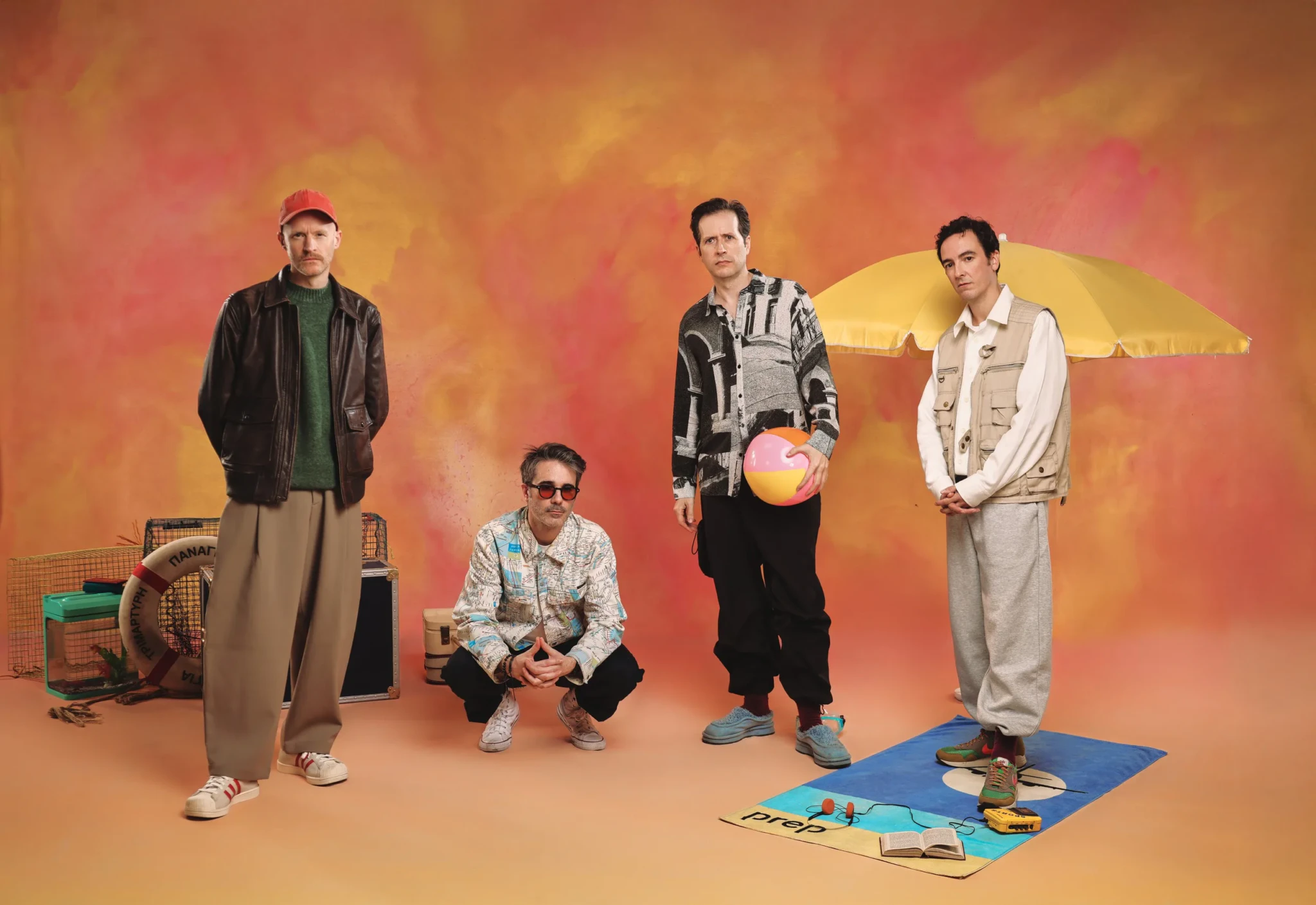PREP in front of an orange backdrop with a yellow beach umbrella and a beach ball