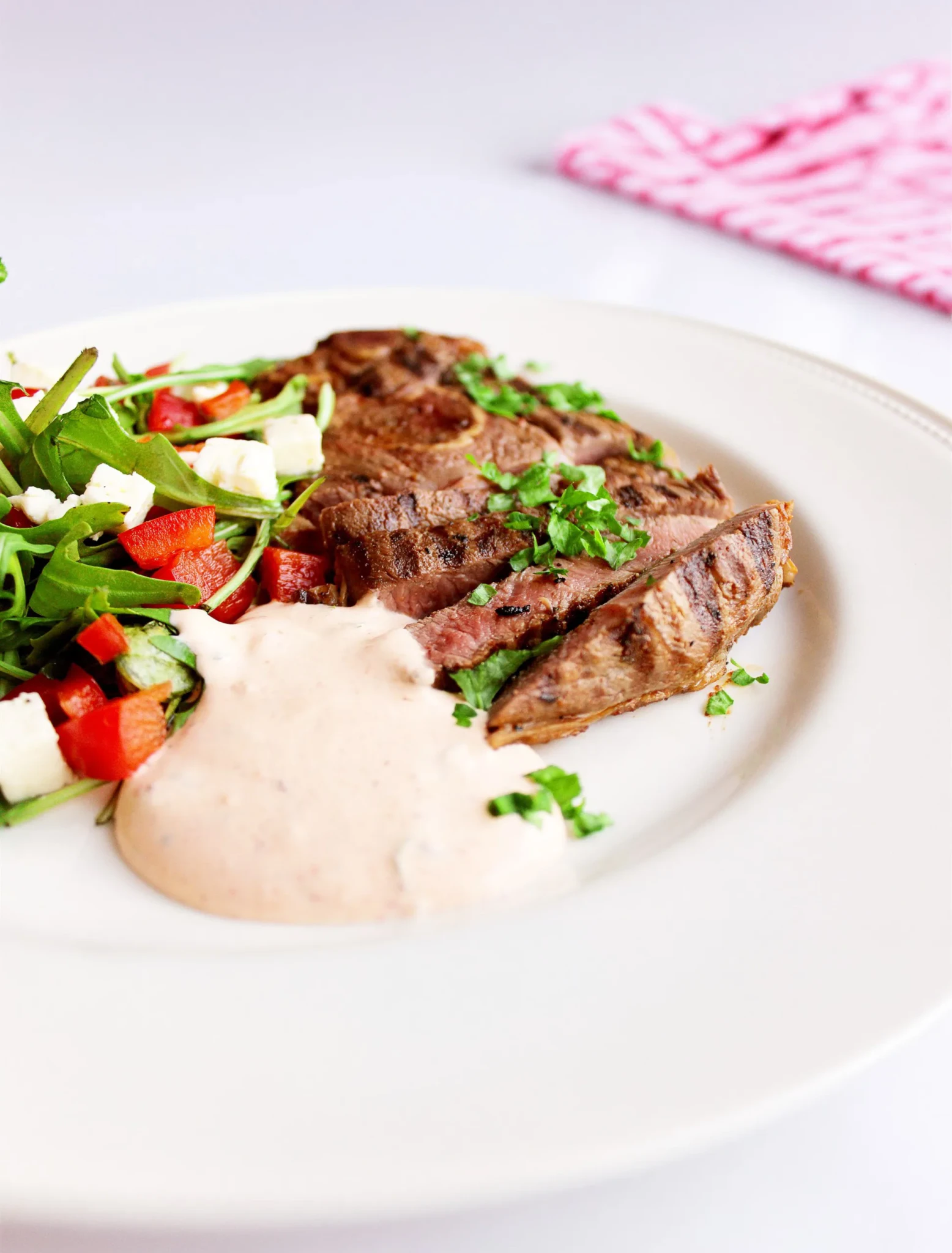 Sliced grilled lamb served with a rocket, red pepper and feta salad and a creamy pink dipping sauce