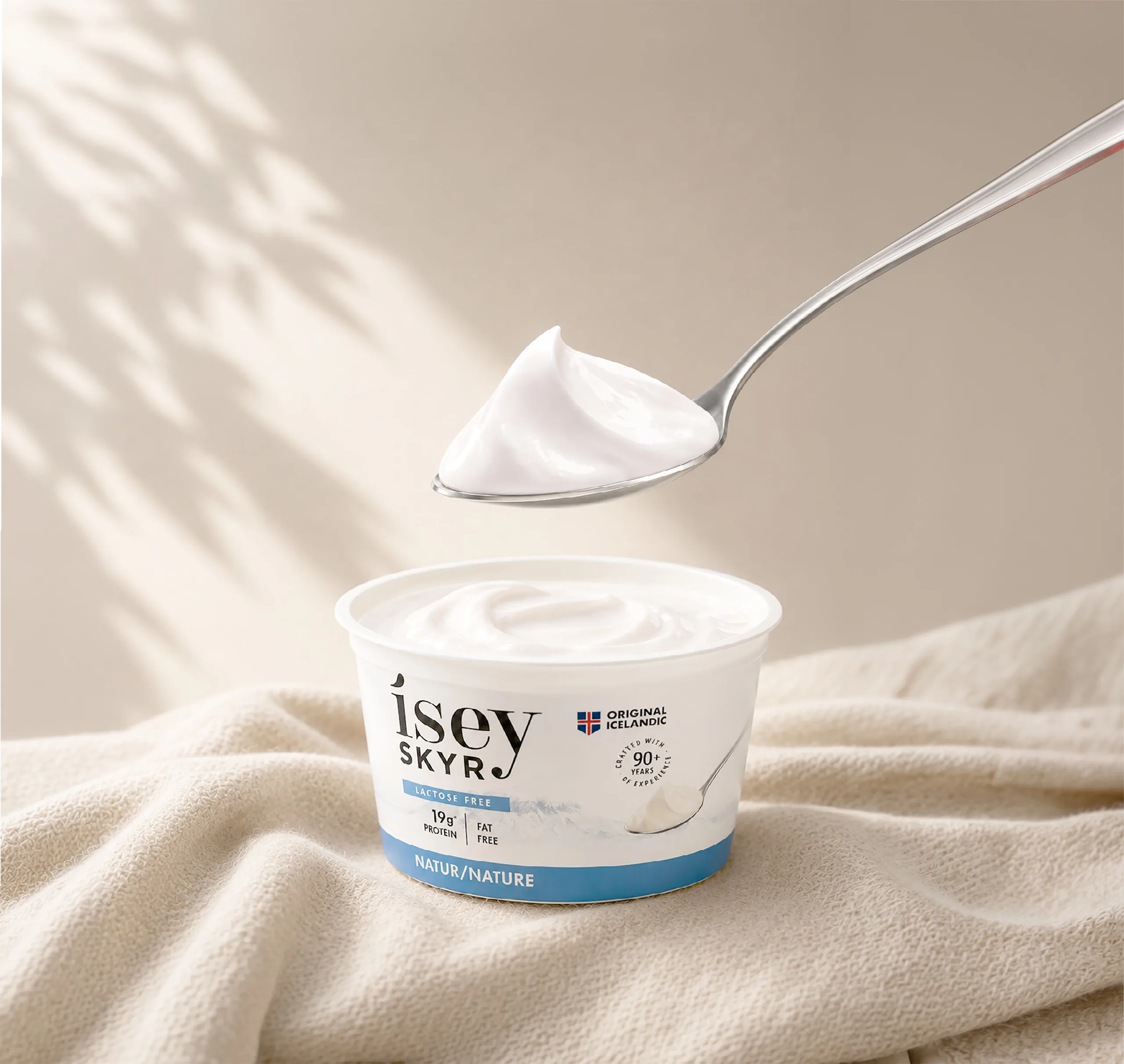 Ísey Skyr Natural 170g cup with a spoonful of skyr lifted above it