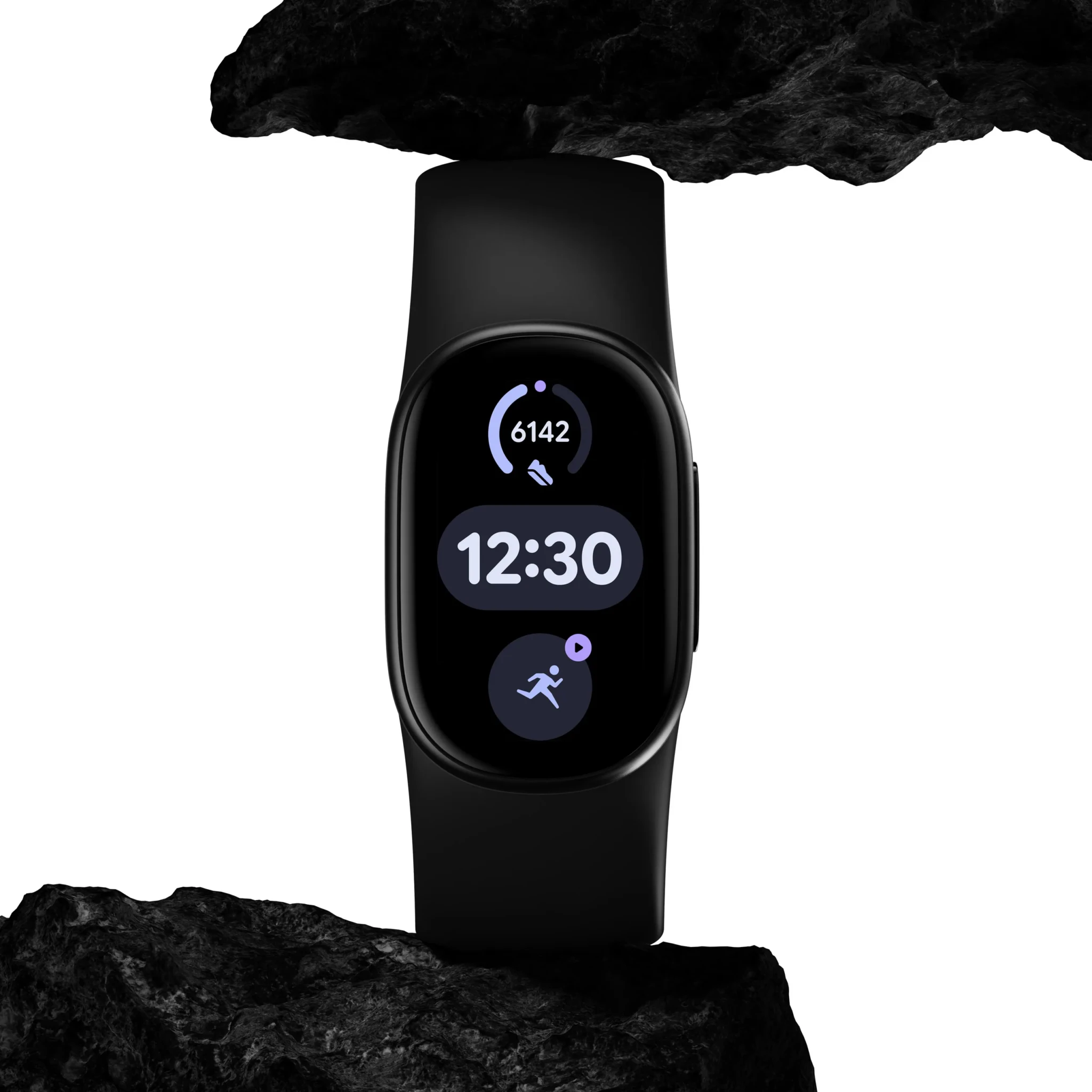 Black Google Fitbit Edge tracker showing the time and step count, propped between two dark rocks