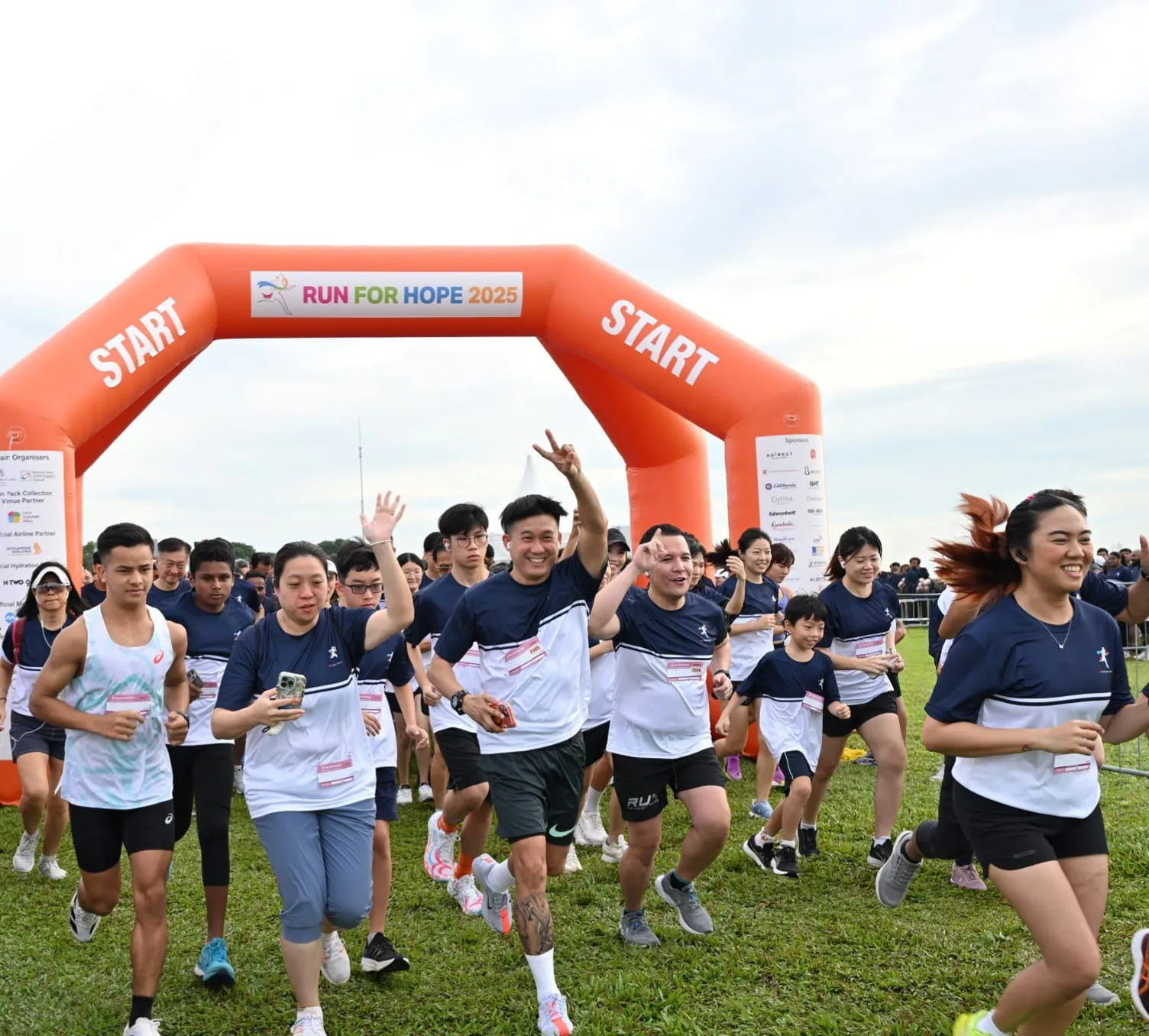 Runners pass under a red inflatable Start arch with the Run For Hope 2025 logo