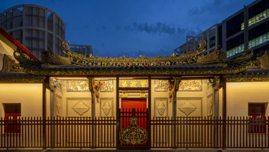 The House of Tan Yeok Nee lit up at dusk, with a golden roof and red doors