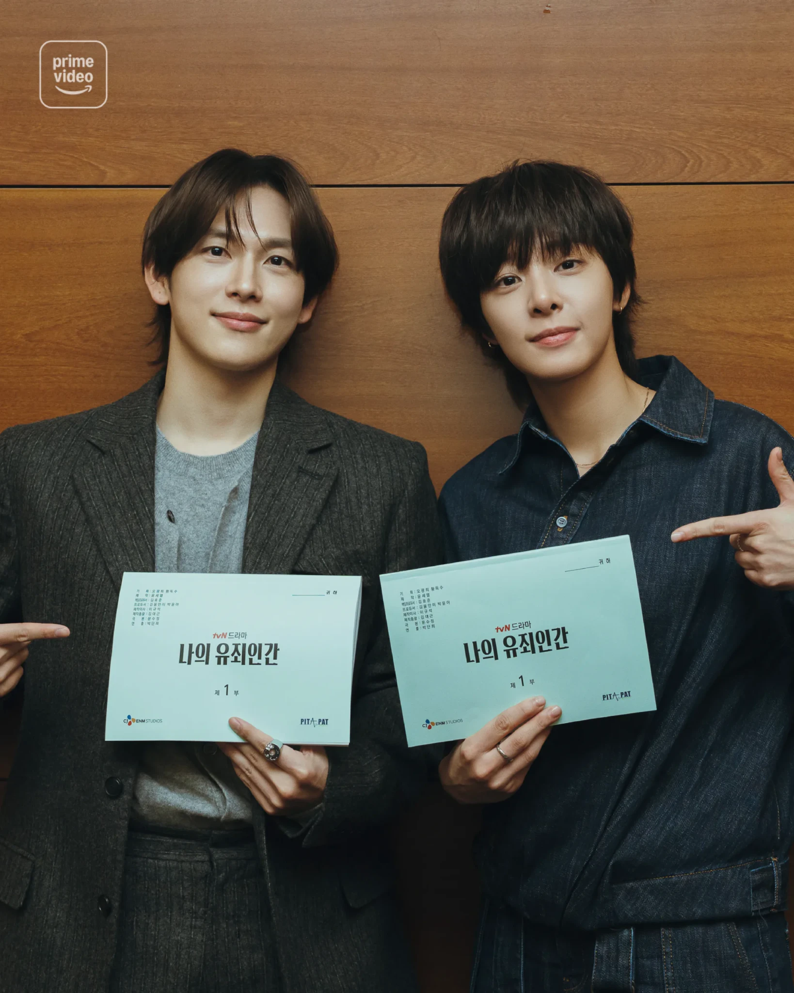 Two cast members hold up their Part 1 scripts for Love in Disguise at a script reading