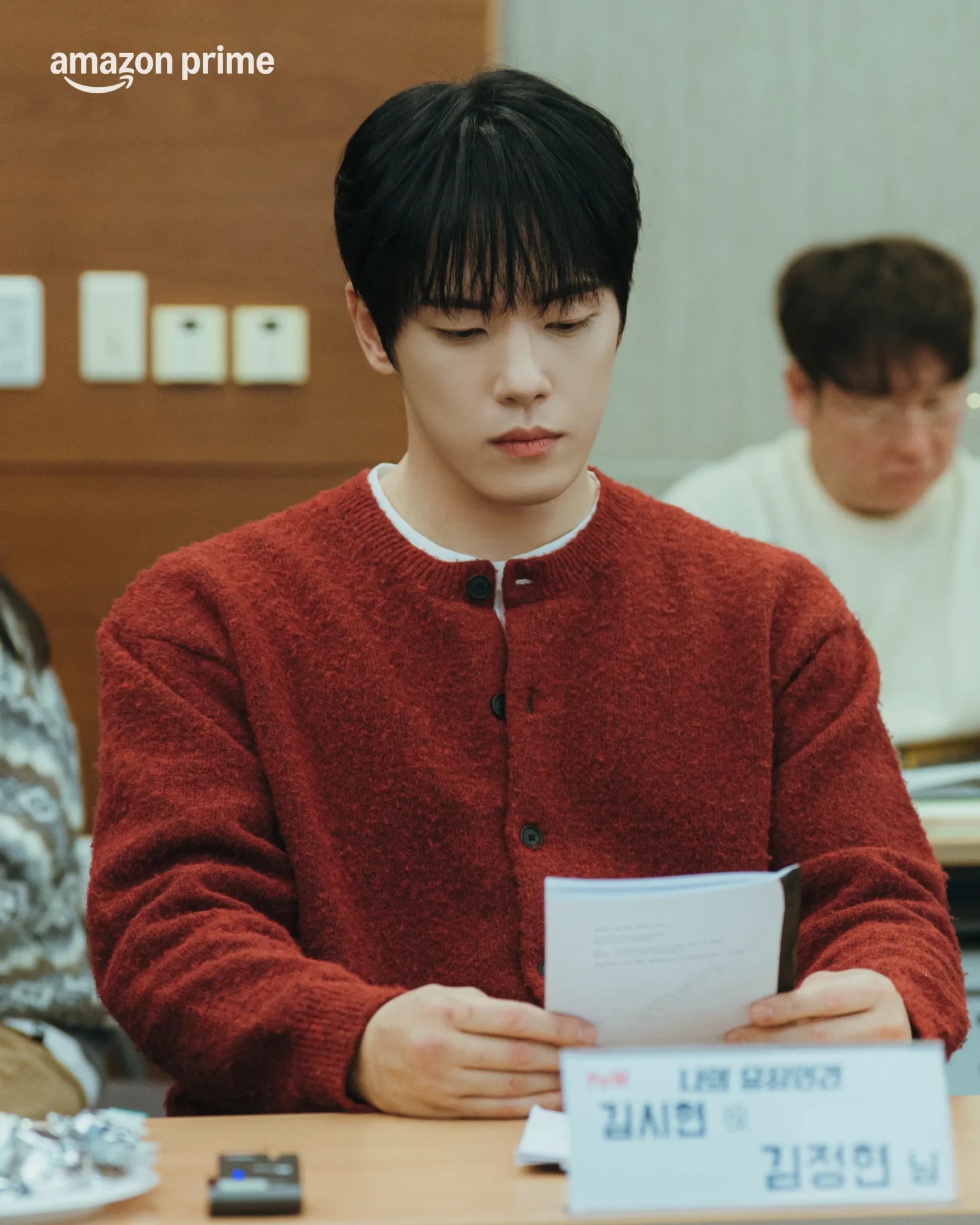 Kim Junghyun reads a script behind his name card at the Love in Disguise script reading
