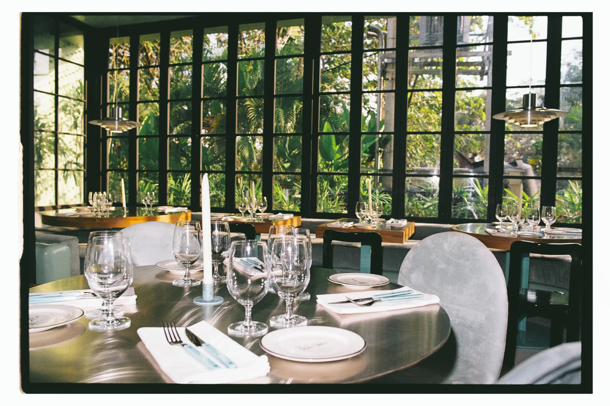 The Win Win dining room at Etta The Place, with set tables beside tall garden windows