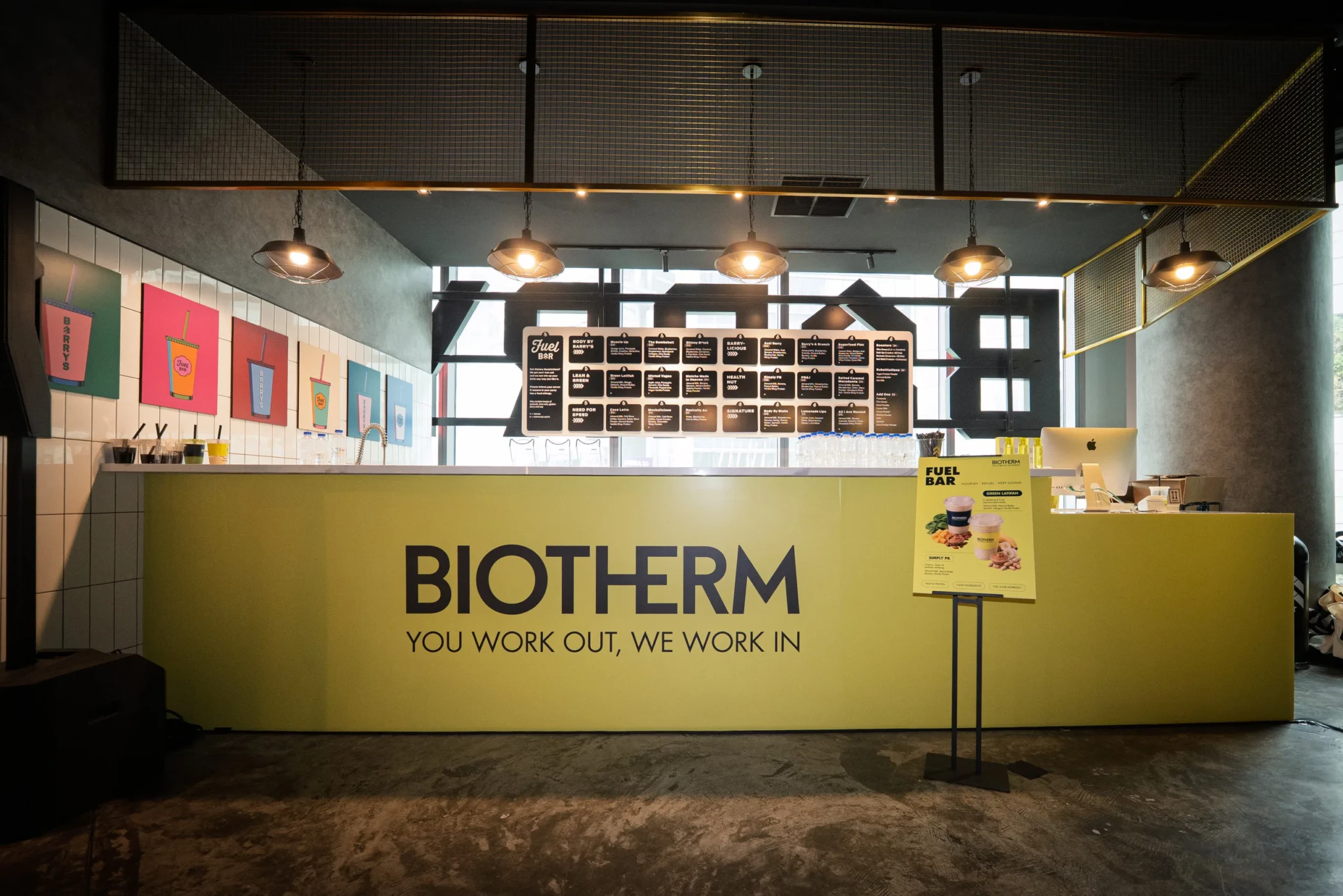 Biotherm Fuel Bar counter with the YOU WORK OUT, WE WORK IN tagline printed on its yellow front
