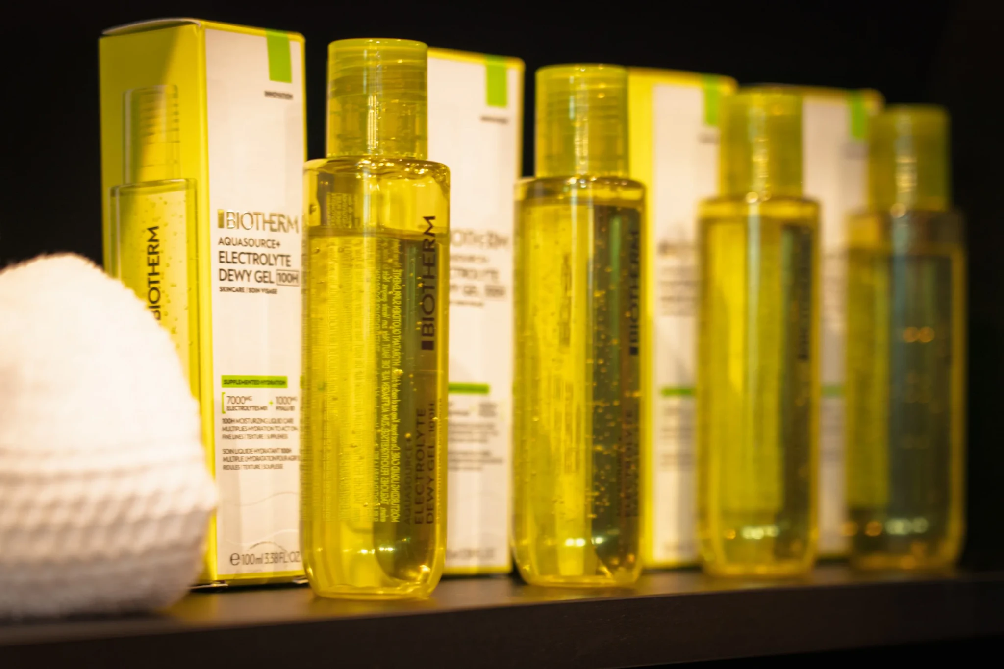 Rows of Biotherm Aquasource+ Electrolyte Dewy Gel 100H bottles beside yellow boxes on a dark shelf