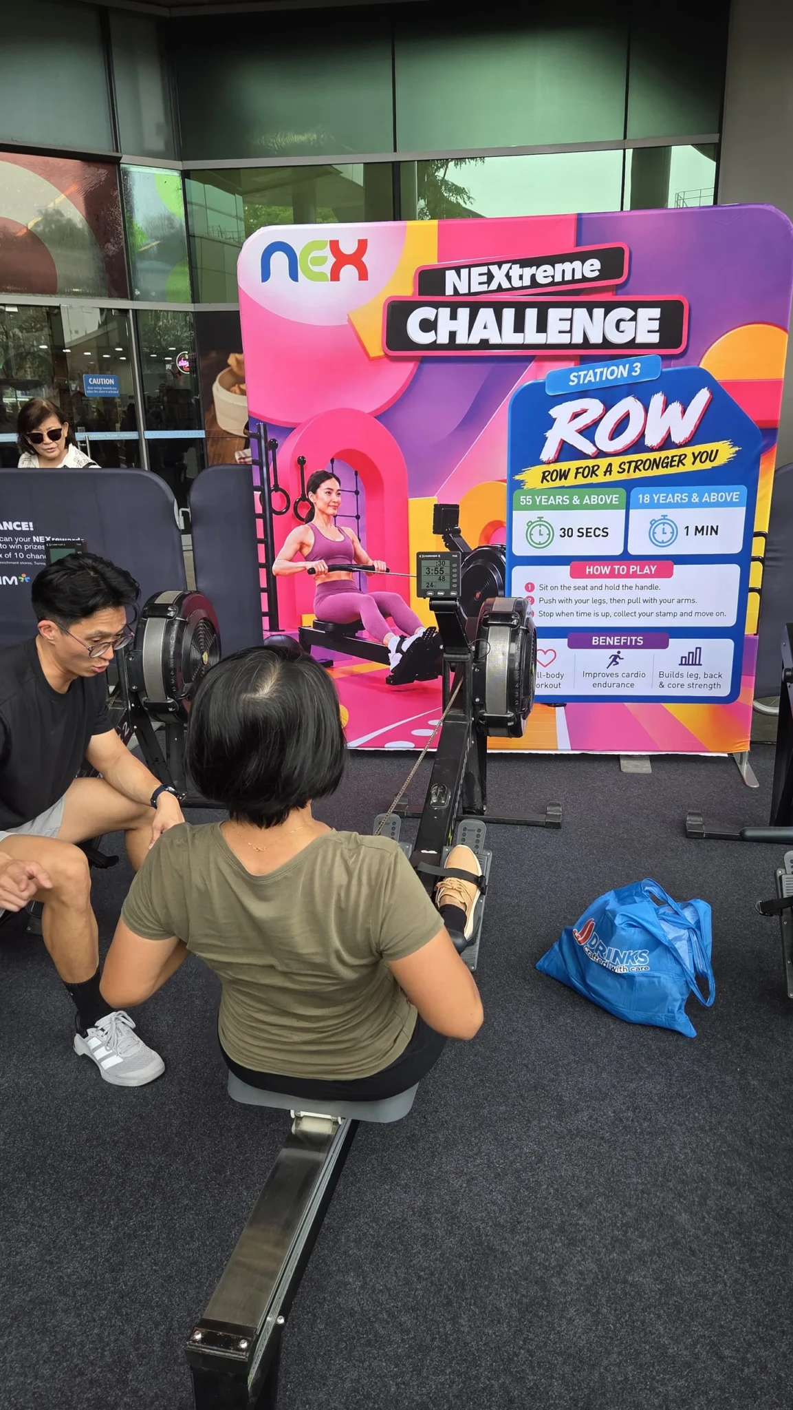 A participant on the rower at a NEXtreme Challenge station at NEX
