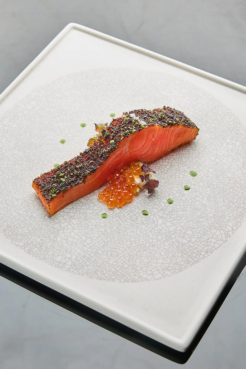 Confit Tasmanian ocean trout with a herb and spice crust, salmon roe and micro greens at Waku Ghin