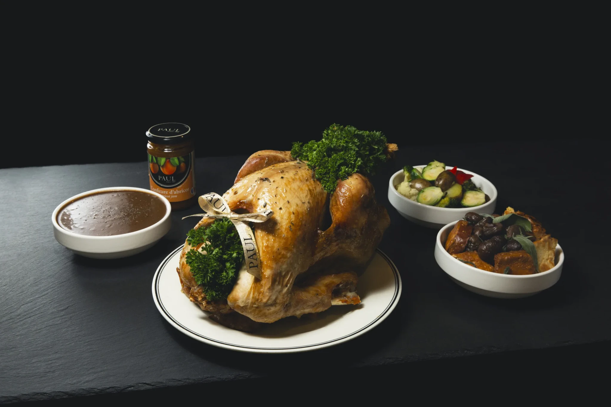 PAUL's Herbes de Provence Roast Turkey tied with a PAUL ribbon, with gravy, apricot jam and roasted vegetables