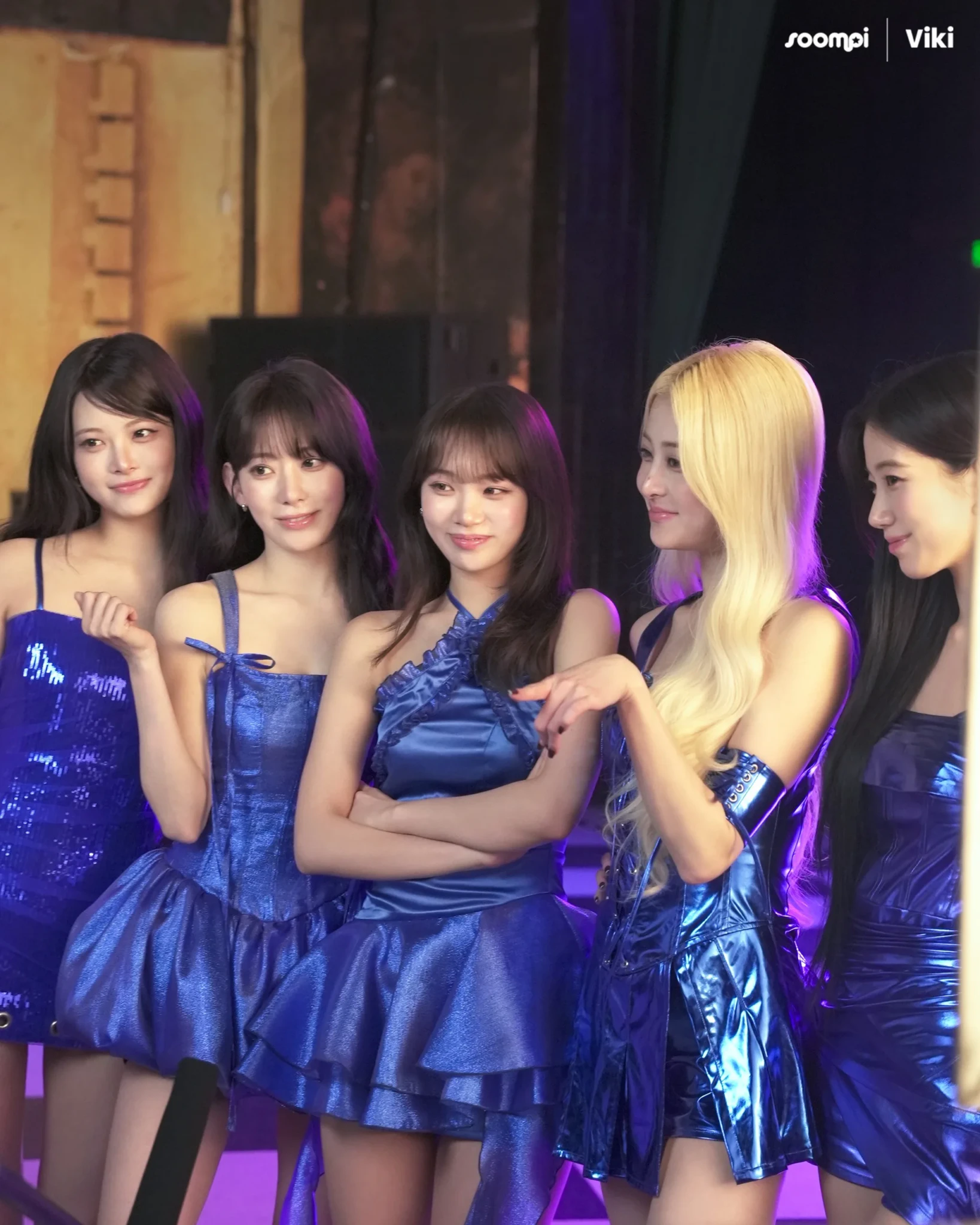 LE SSERAFIM members posing together in matching blue outfits for Rakuten Viki's Viki Pass It On campaign