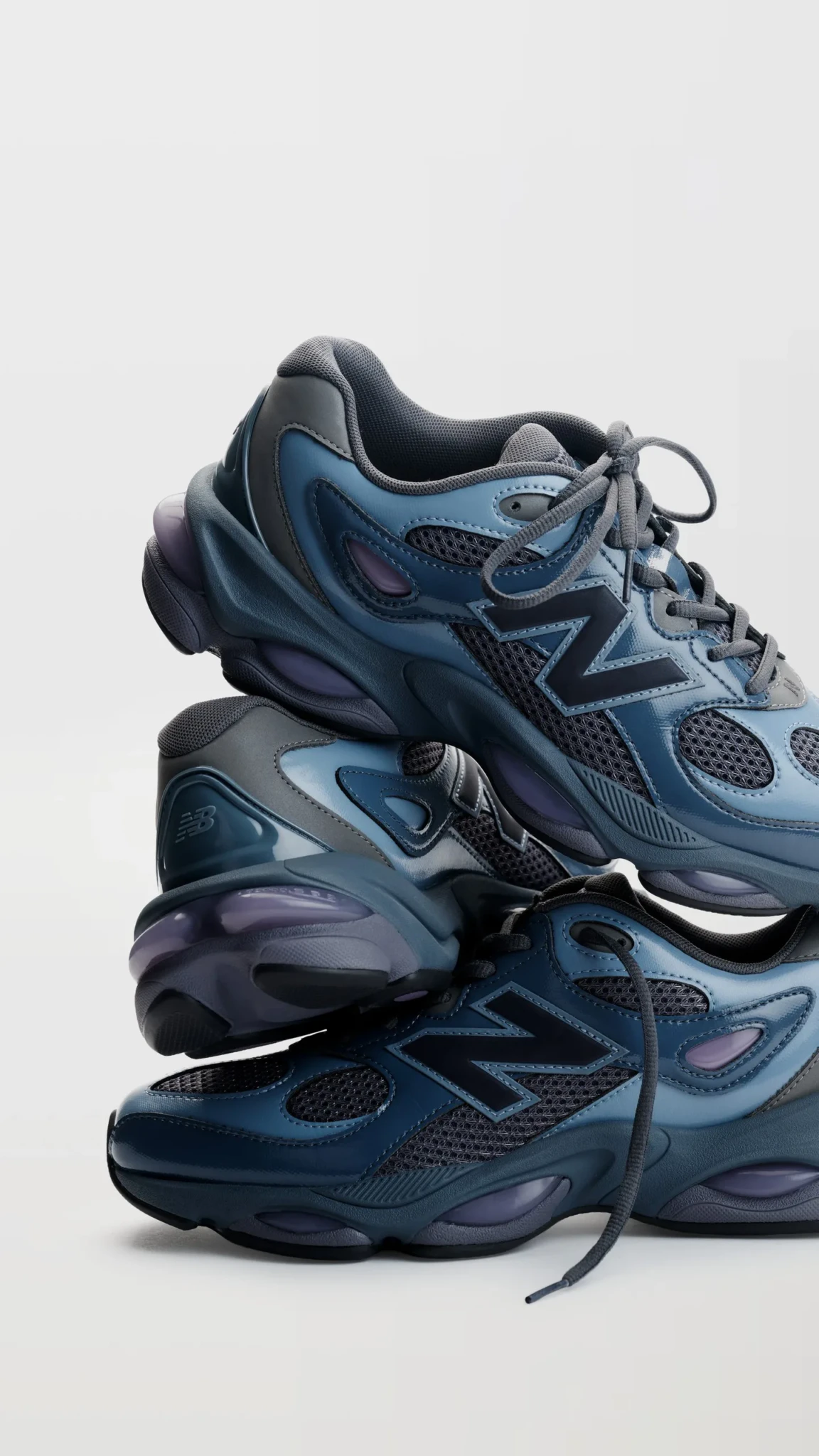 Two pairs of the New Balance 983 in blue-grey stacked with loose laces, showing the oval ABZORB pods and N logo