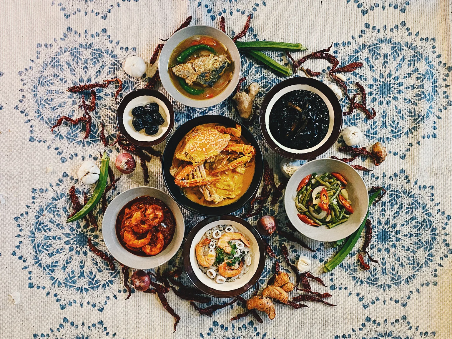 A spread of Orang Pulau dishes including crab, sambal shrimp, squid rice, fish curry and long beans