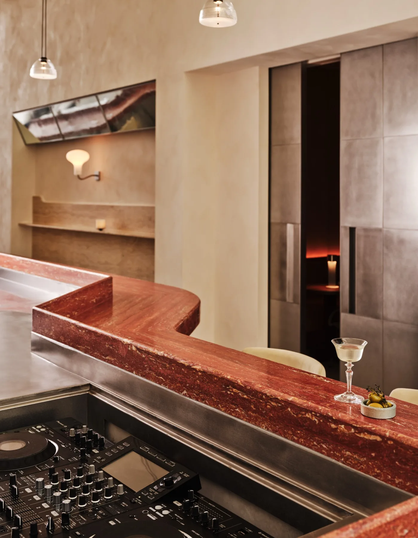The curved red marble bar at Bar Somma with a DJ setup built into the counter