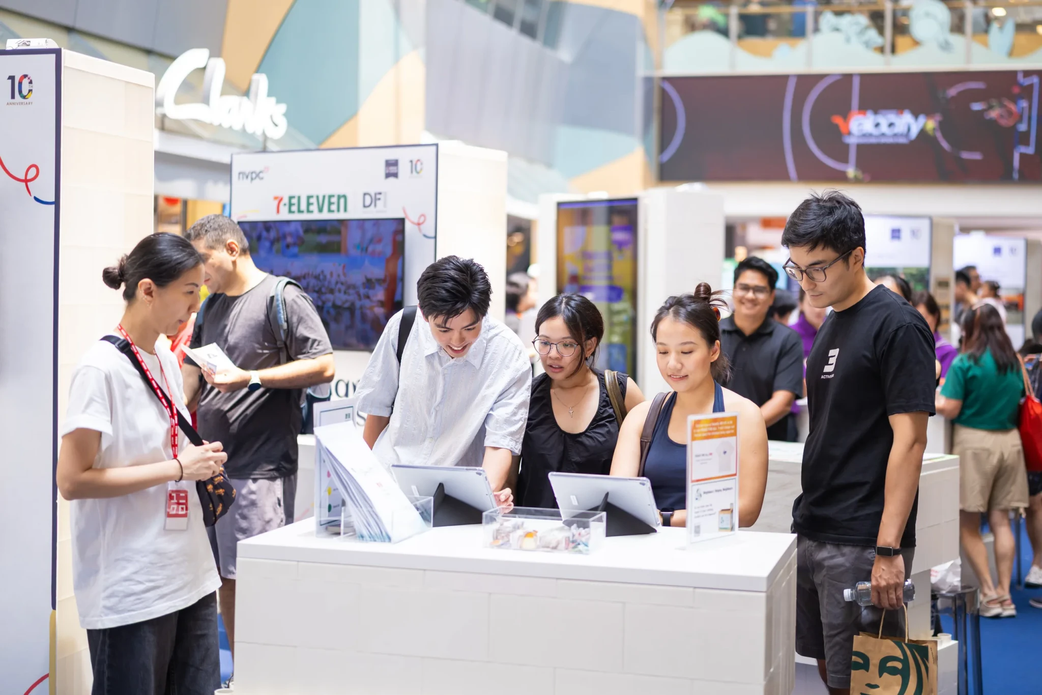 Visitors at tablets at the COG10 Travelling Showcase stand at Velocity @ Novena Square