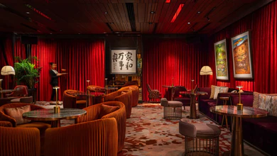 ANTI:DOTE bar interior at Fairmont Singapore with red velvet curtains, velvet lounge seating and marble-topped tables