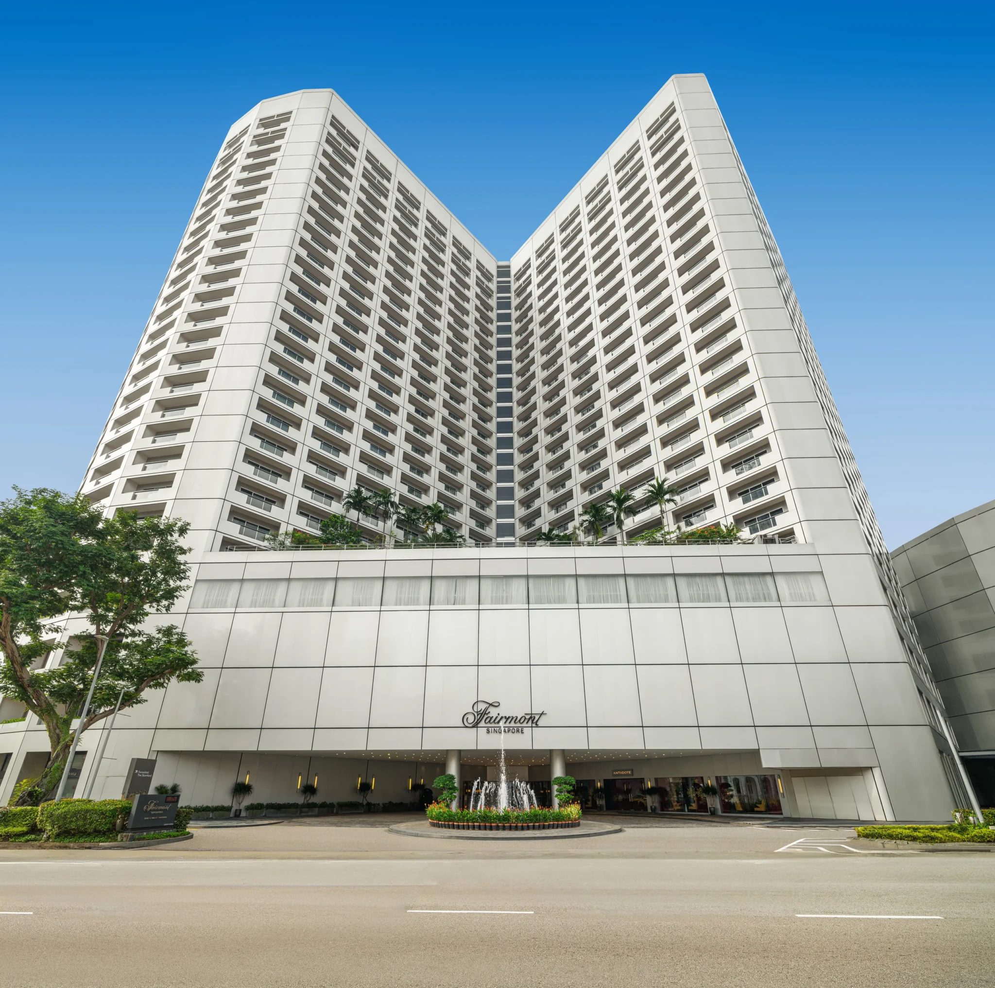 Fairmont Singapore hotel tower with its entrance driveway and fountain