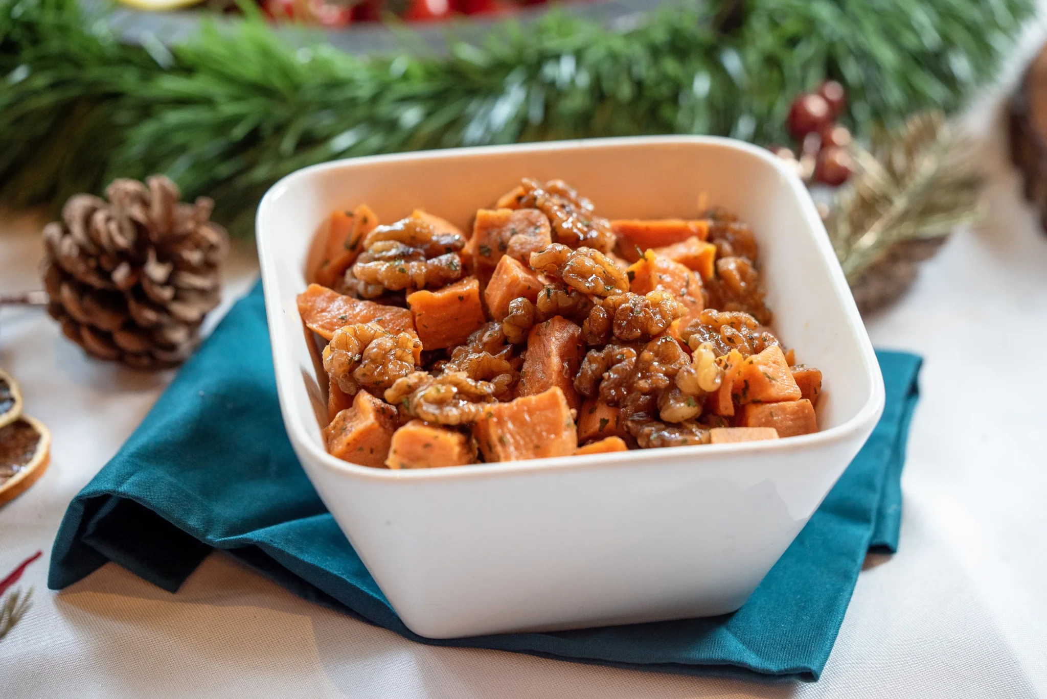 Honey roasted sweet potato salad with walnuts in a white square bowl