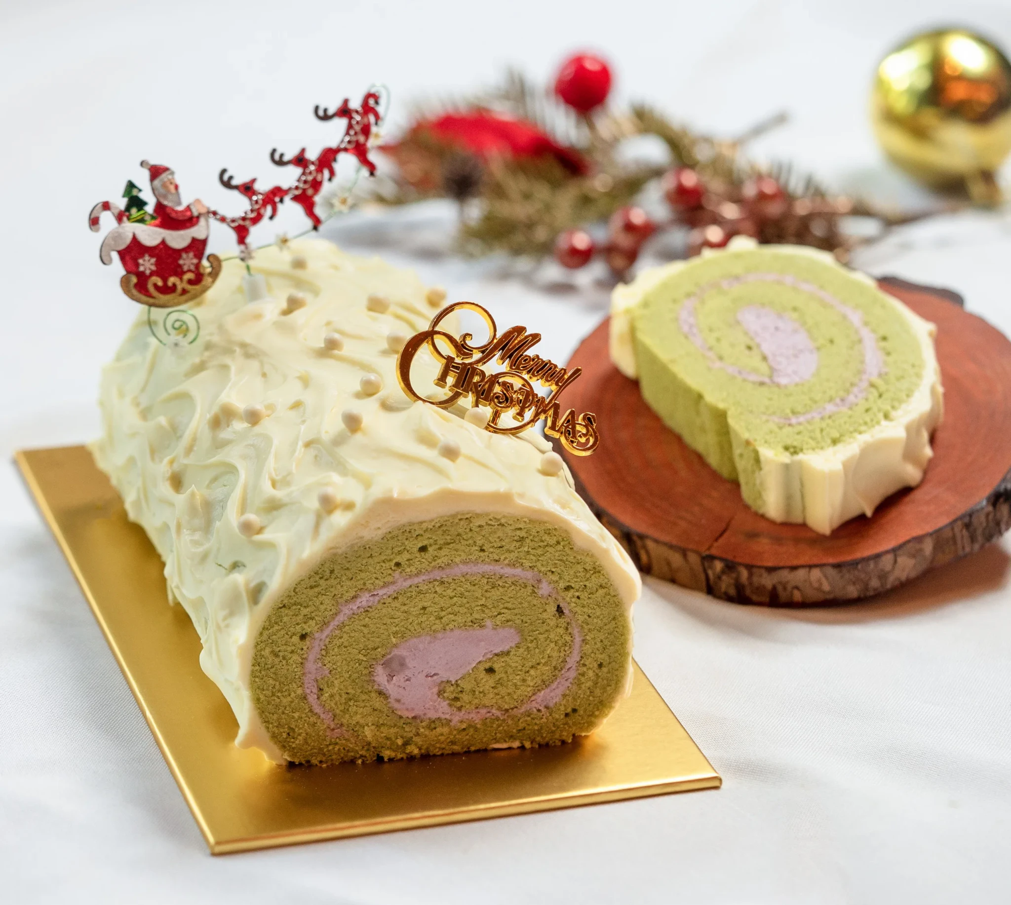 Matcha taro Yule Log with a Santa sleigh topper and a cut slice
