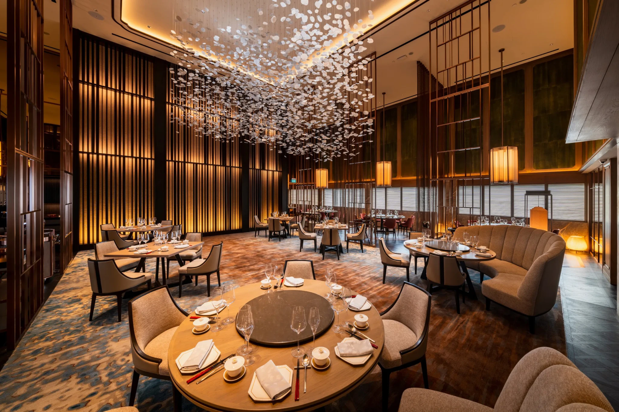 The Main Dining Room at Shisen Hanten by Chen Kentaro with round tables set beneath a suspended white installation