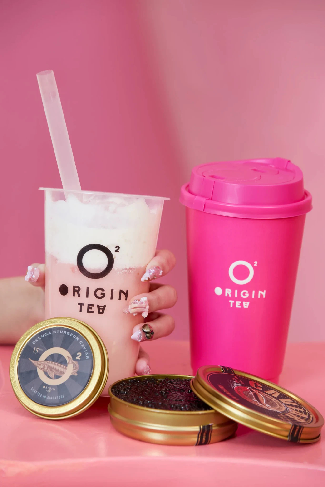 Riri's Pink Crown drink with rose petals beside beluga caviar tins