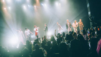 ONE OR EIGHT perform together onstage under red and blue lighting.