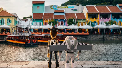 Woody and Buzz Lightyear figures on the riverside promenade facing the Singapore River and shophouses
