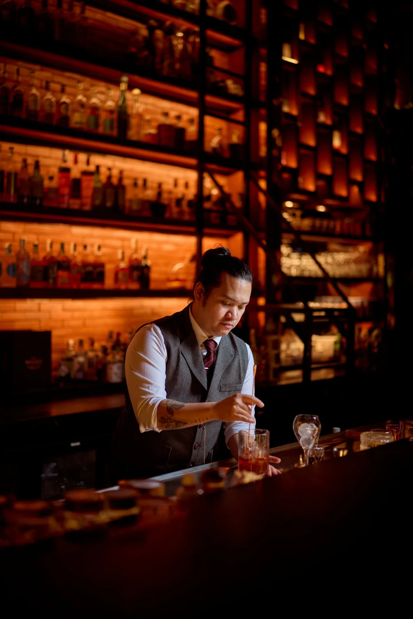 Edu Zamora garnishing a whisky cocktail behind a bar