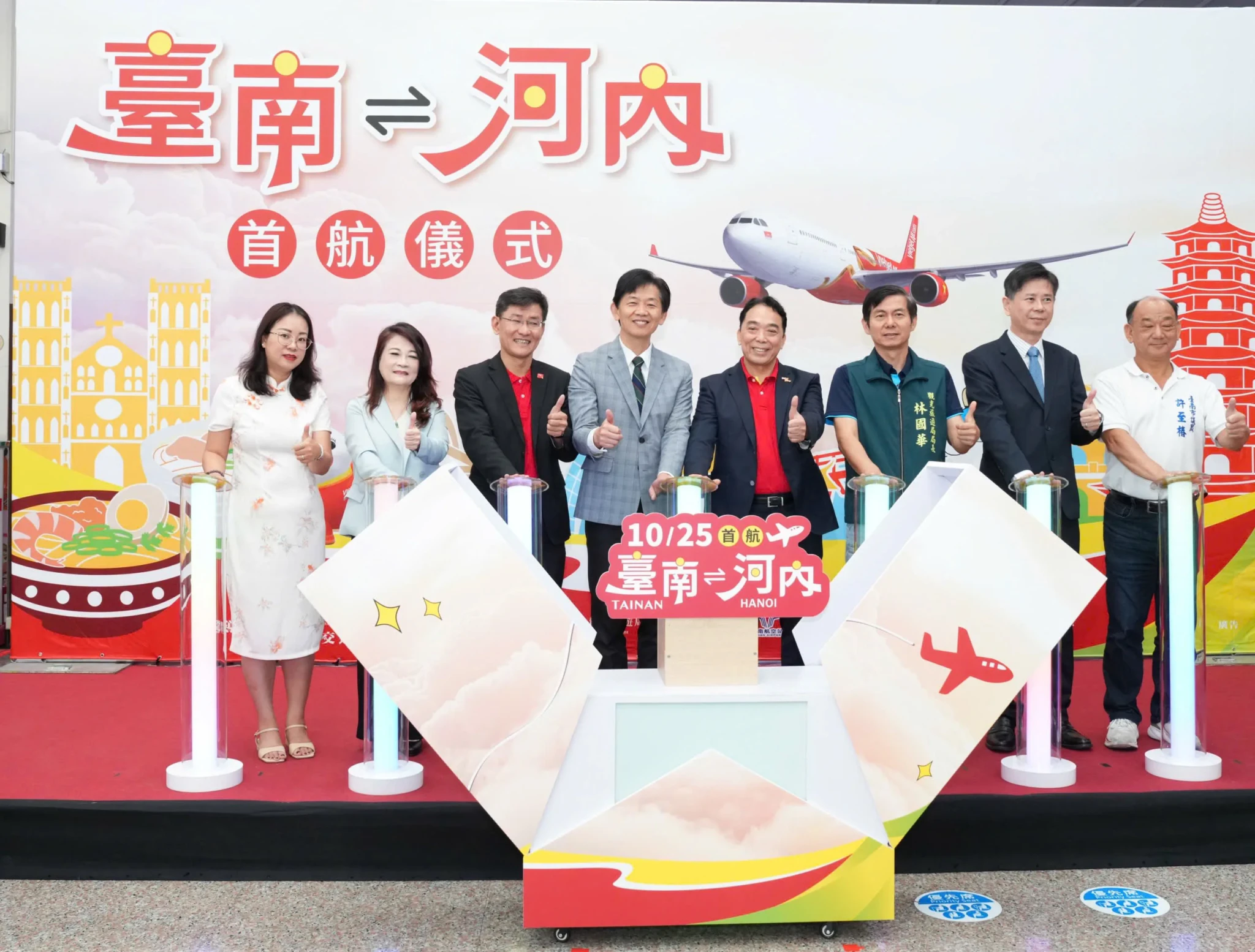 Vietjet and Tainan City leaders at the inauguration ceremony for the Tainan to Hanoi route, with a backdrop of a Vietjet aircraft and Tainan landmarks