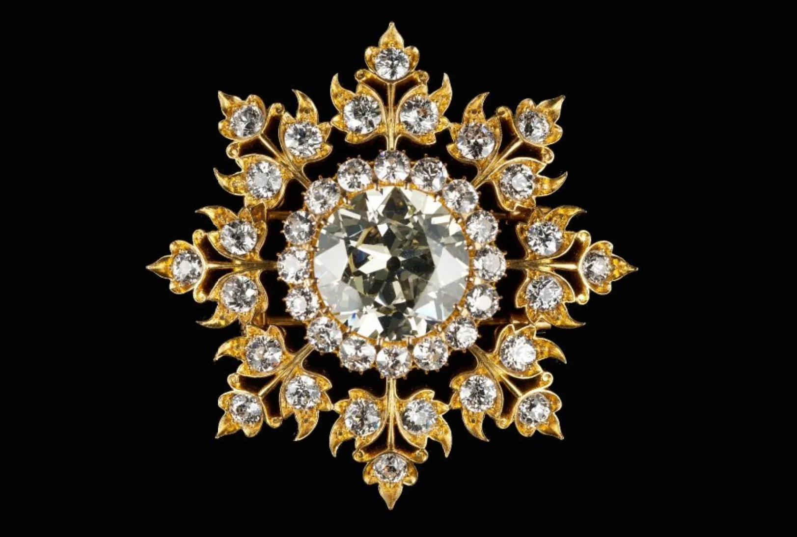An eight-pointed flowerhead kerosang, a gold brooch set with a large central diamond surrounded by smaller diamonds