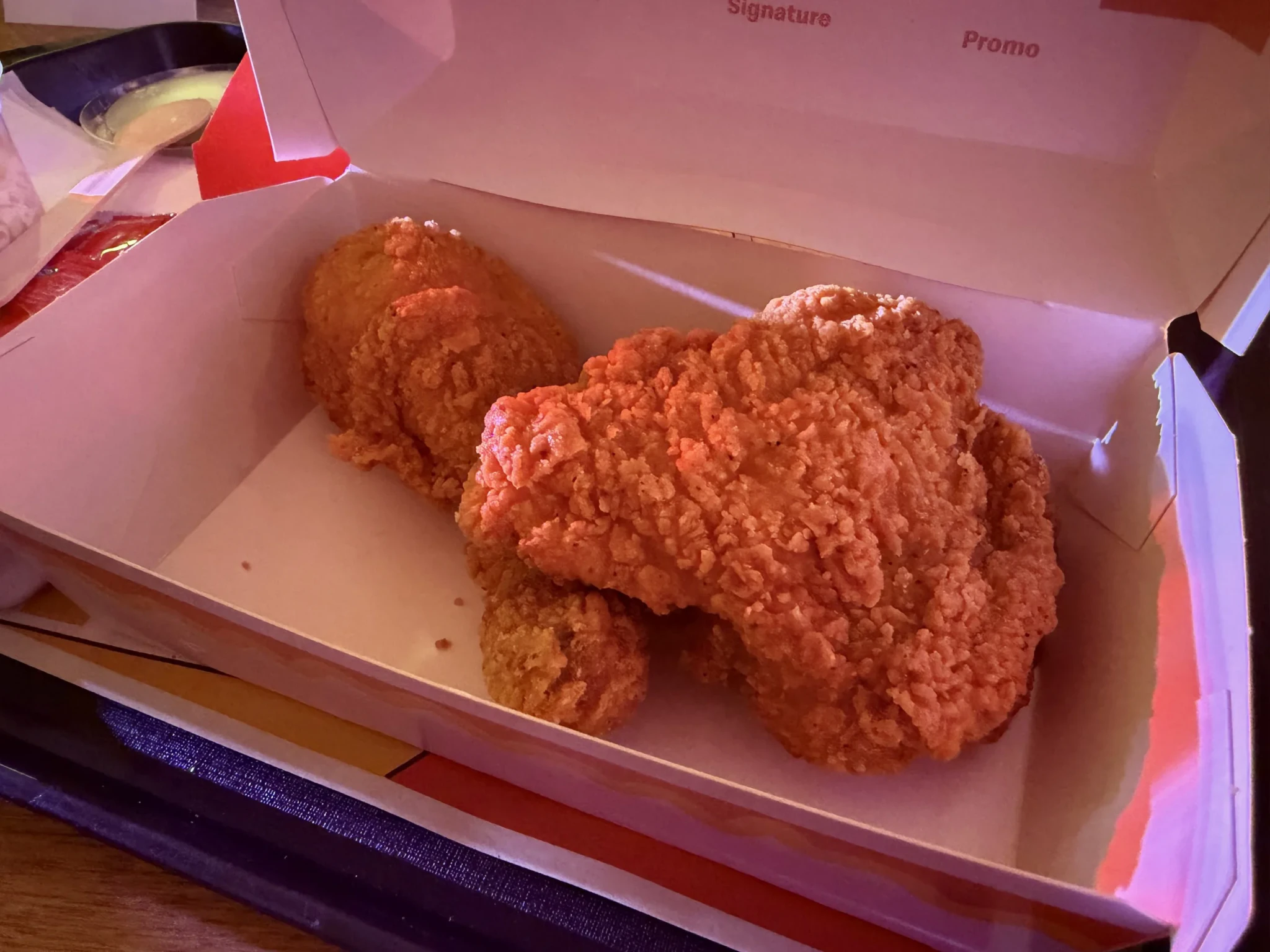 Two pieces of spicy McCrispy Fried Chicken in an open McDonald's box