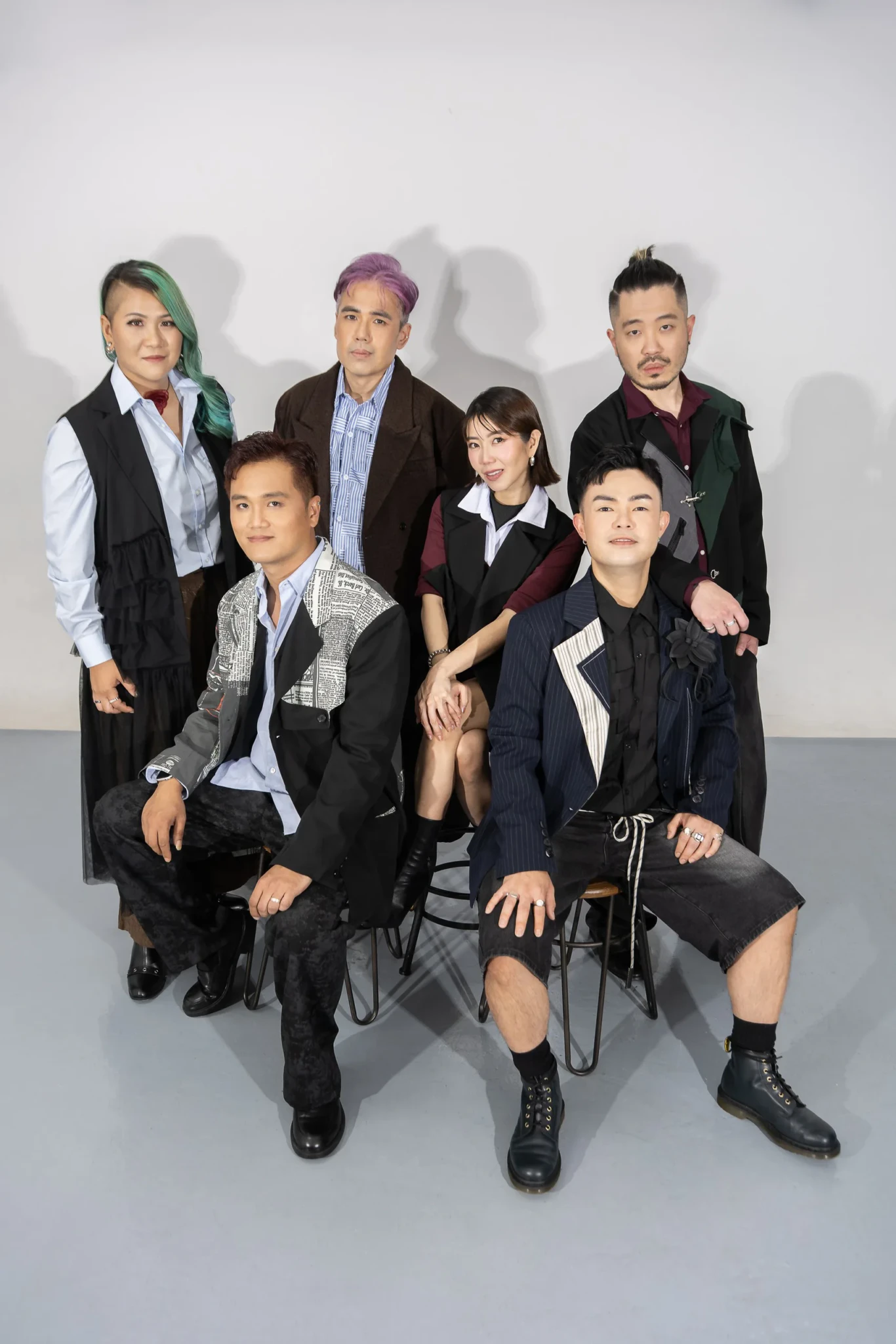 The six members of MICappella posing together in a studio against a grey backdrop
