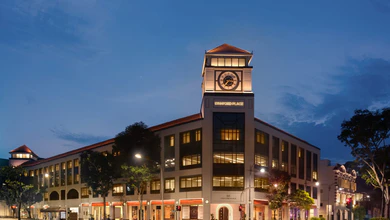 The lit facade and clock tower of Stamford Place at dusk